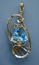 Wire jewelry pendant displayed on a stand