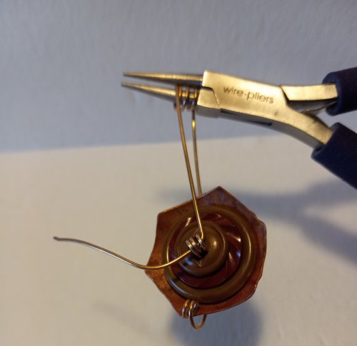 Judy Freyer Thompson's Stacked Button Charms - , Contemporary Wire Jewelry, Cutting, Cutting Tool, Cutters, Dapping, Dapping Jewelry, How To Punch Holes, Hole Punching, Punch A Hole, Loops, Wire Loop, Wrapped Wire Loop, Sawing, Saw, Wire Saw, Butane Torch, Soldering, Solder, Bring the longer tail up and around