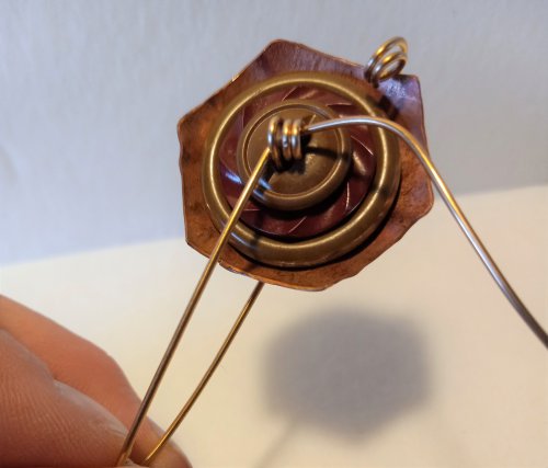 Judy Freyer Thompson's Stacked Button Charms - , Contemporary Wire Jewelry, Cutting, Cutting Tool, Cutters, Dapping, Dapping Jewelry, How To Punch Holes, Hole Punching, Punch A Hole, Loops, Wire Loop, Wrapped Wire Loop, Sawing, Saw, Wire Saw, Butane Torch, Soldering, Solder, Thread the end of the longer piece through the first coil