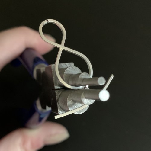 Kendra Austin's Infinity Earrings - Form the inner elements, Contemporary Wire Jewelry, Filing, Finishing, Forging, Forging Jewelry, Jewelry Forging, Lashing, Wire Lashing, Loops, Wire Loop, Wrapped Wire Loop, Use your flat nosed pliers to pull the tail around the 5mm step.