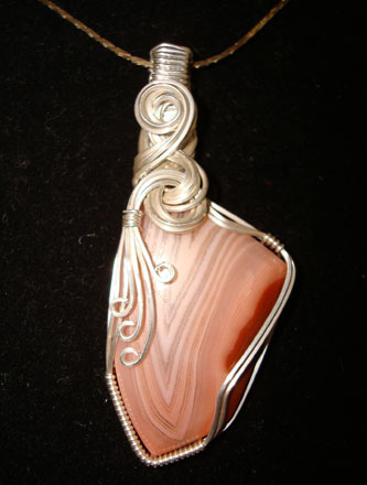 Lake Superior Agate cabbed and wrapped in sterling silver wire by Marie Frazier. Click this image to discover more about Lake Superior agates!