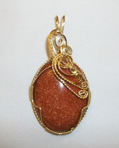 Joan Madouse wrapped this brown goldstone pendant in gold plated wire.