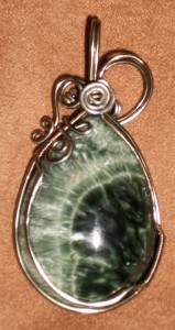 Shawnea Hardesty created this seraphinite pendant using gun metal enameled wire and a green seraphinite cabochon with a dramatic crystal structure.